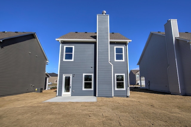 rear view of house with central AC unit and a patio area