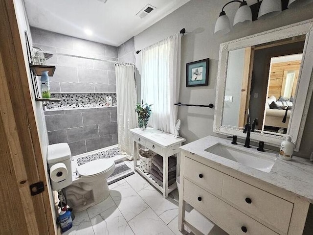 bathroom featuring curtained shower, vanity, and toilet