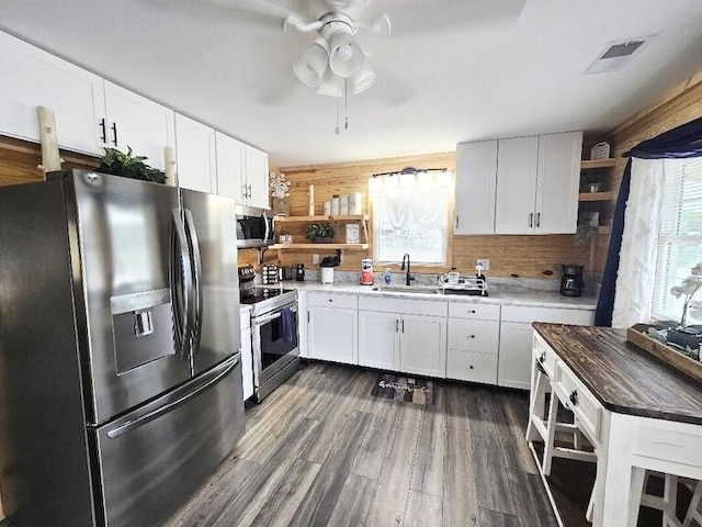 kitchen featuring ceiling fan, sink, butcher block countertops, white cabinets, and appliances with stainless steel finishes