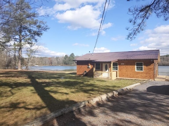 exterior space featuring a lawn and a water view