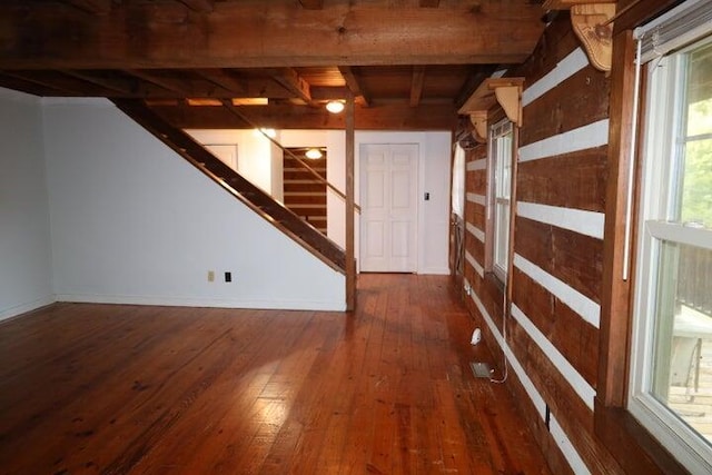 basement featuring a wealth of natural light and dark hardwood / wood-style flooring