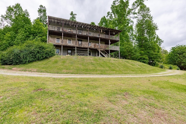 back of property featuring a wooden deck and a lawn