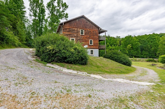 view of property exterior with a deck and a lawn