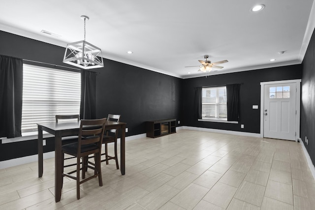 dining space featuring ceiling fan with notable chandelier and crown molding