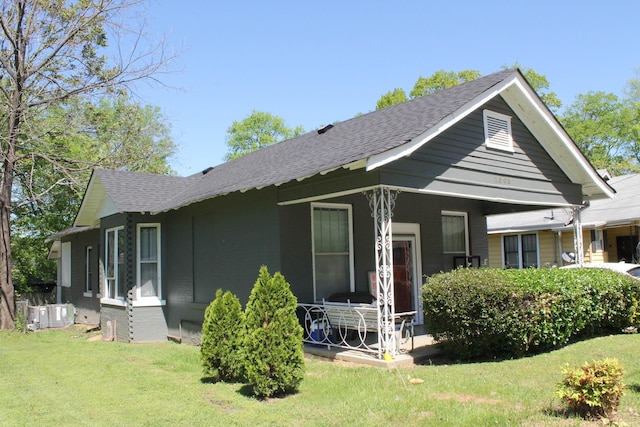 rear view of property with covered porch and a yard