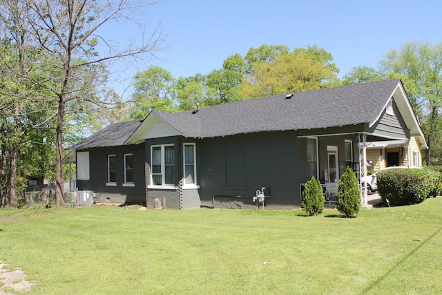 rear view of property featuring a lawn