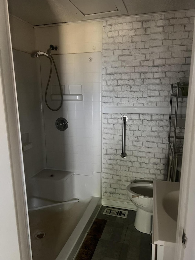 bathroom featuring tile patterned flooring, vanity, toilet, and walk in shower