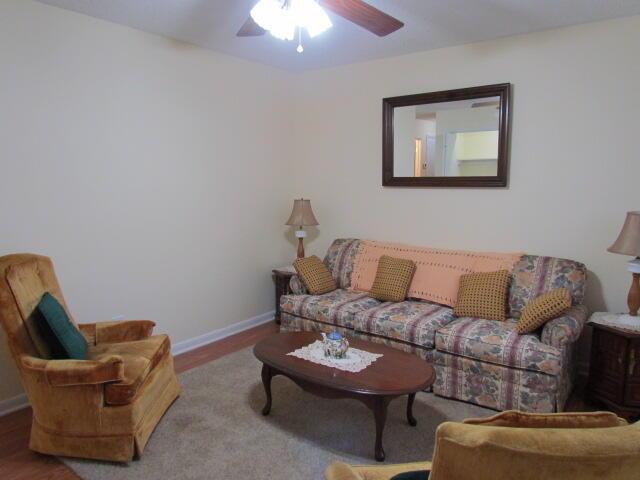 living room featuring hardwood / wood-style floors and ceiling fan