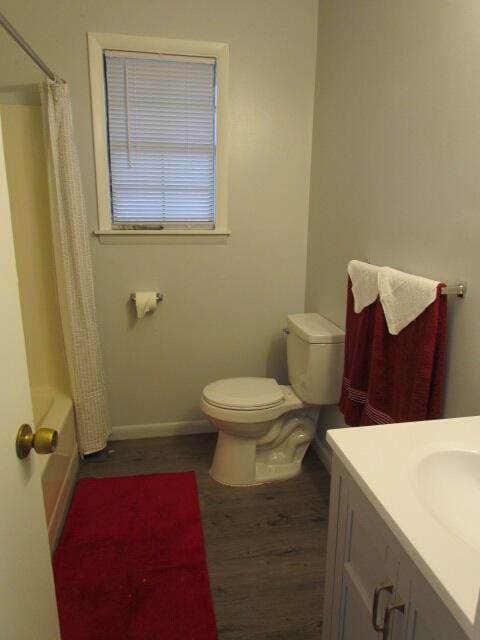 full bathroom featuring wood-type flooring, vanity, toilet, and shower / bathtub combination with curtain