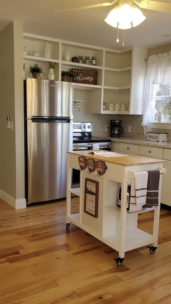 kitchen with white cabinetry, stainless steel appliances, and light hardwood / wood-style floors