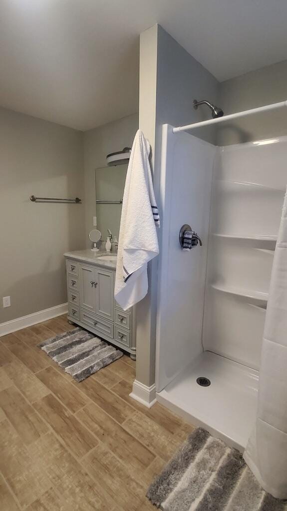 bathroom featuring a shower, vanity, and wood-type flooring