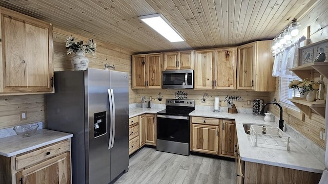 kitchen with sink, wooden walls, light wood-type flooring, appliances with stainless steel finishes, and wood ceiling