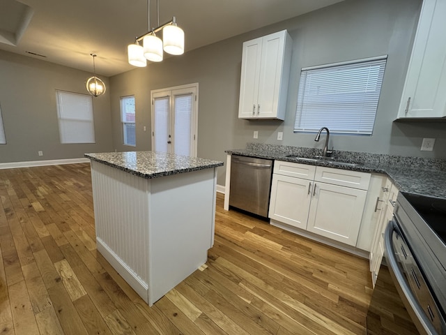 kitchen with sink, stainless steel appliances, light hardwood / wood-style flooring, pendant lighting, and white cabinets