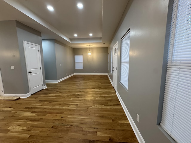 unfurnished room featuring a raised ceiling and dark wood-type flooring