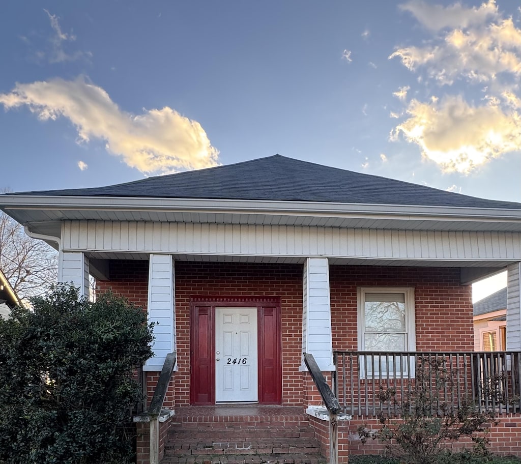 exterior entry at dusk featuring a porch