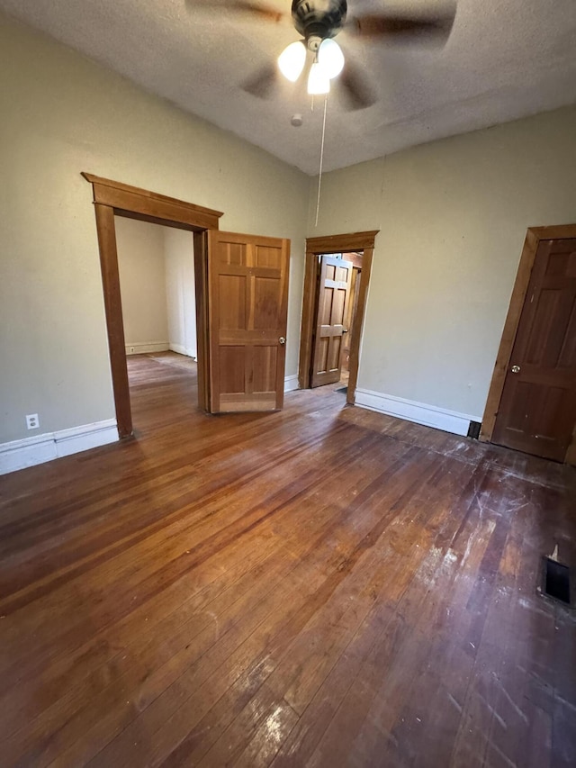 interior space with visible vents, baseboards, hardwood / wood-style flooring, ceiling fan, and a textured ceiling