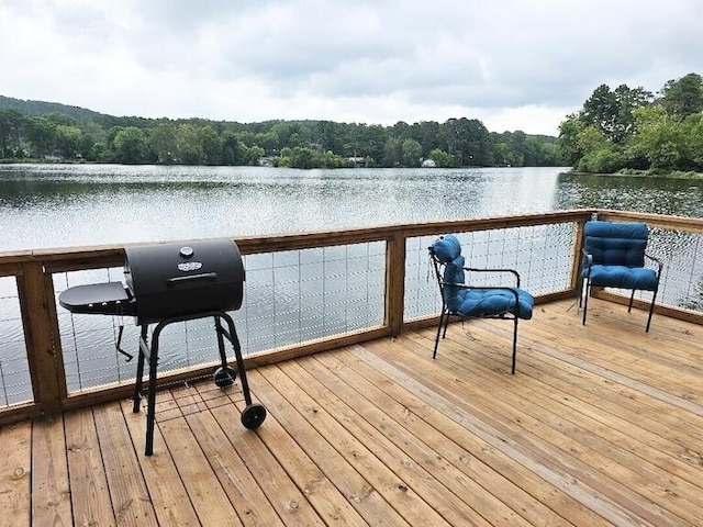 deck with a water view and a grill