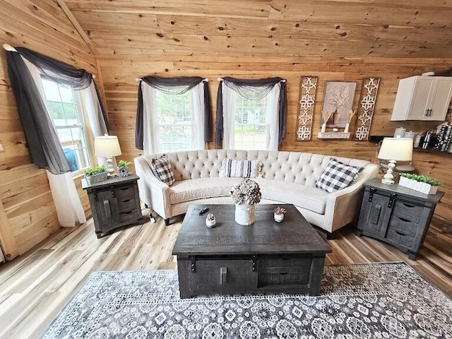 living room featuring light wood-type flooring, vaulted ceiling, wooden ceiling, and wood walls