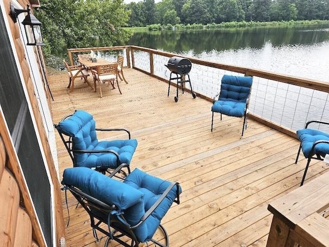 wooden terrace with grilling area and a water view