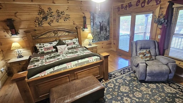 bedroom with hardwood / wood-style floors and wooden walls