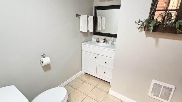 bathroom with tile patterned flooring, vanity, and toilet