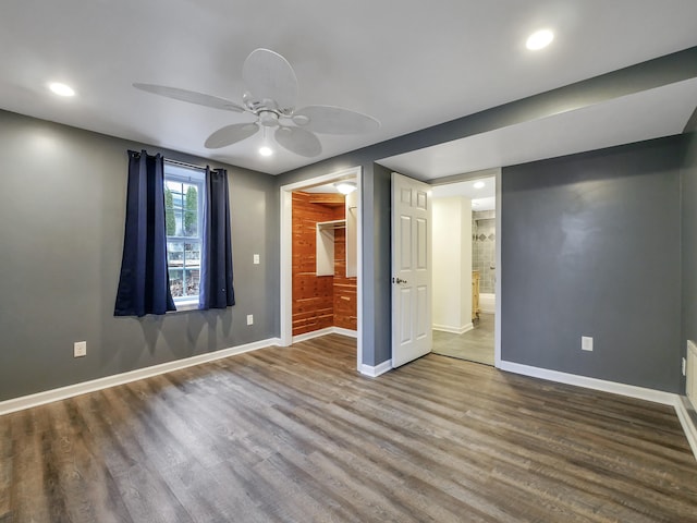 unfurnished bedroom featuring hardwood / wood-style floors, ensuite bath, and ceiling fan