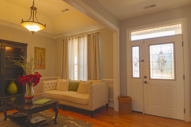 foyer entrance featuring hardwood / wood-style floors and ornamental molding