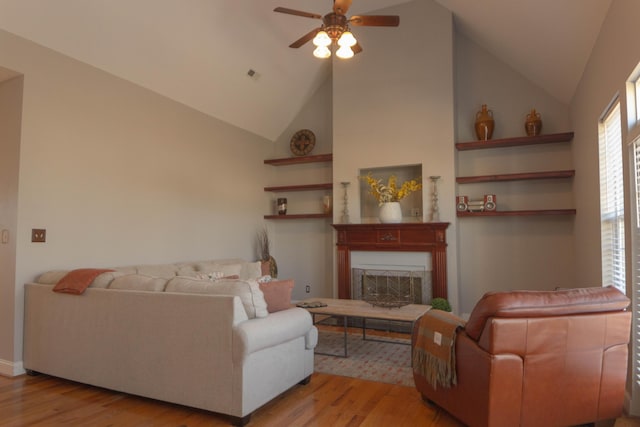 living room featuring ceiling fan, lofted ceiling, and light hardwood / wood-style flooring