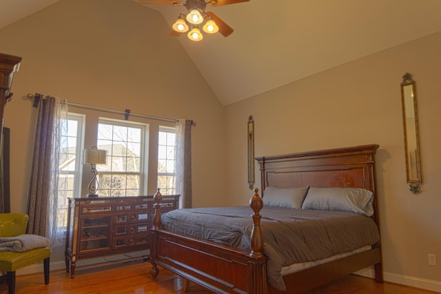 bedroom with ceiling fan, high vaulted ceiling, and hardwood / wood-style flooring