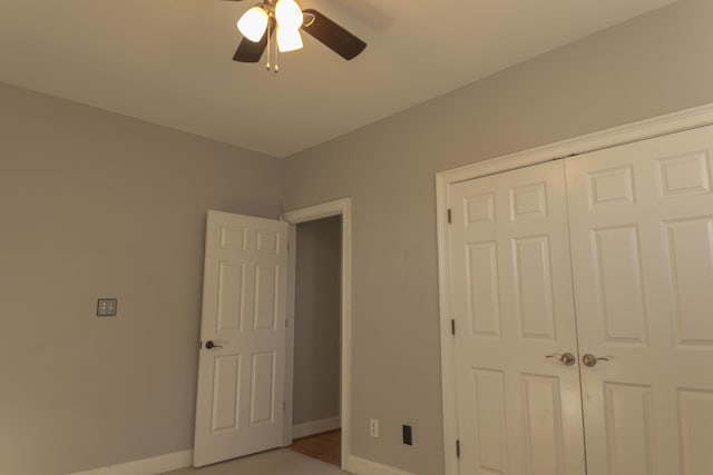 unfurnished bedroom featuring ceiling fan and a closet