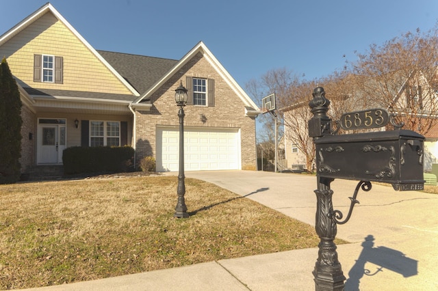 traditional-style house featuring brick siding, a garage, driveway, and a front lawn