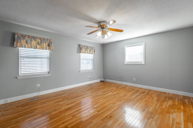 empty room featuring ceiling fan, a textured ceiling, and hardwood / wood-style flooring