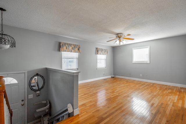 interior space featuring ceiling fan, light hardwood / wood-style floors, and a textured ceiling