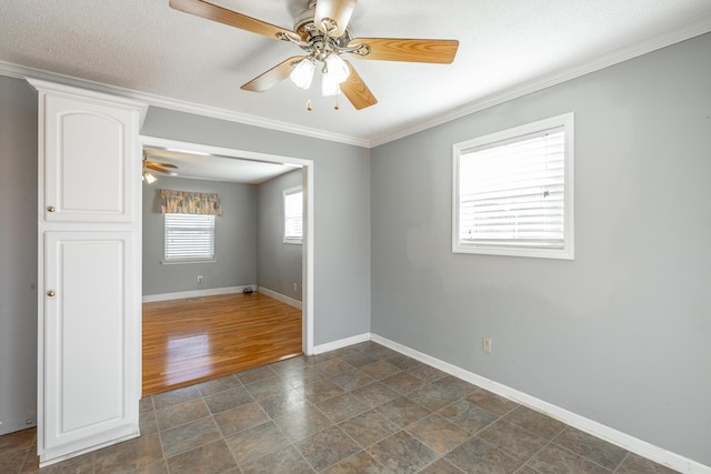 empty room featuring ceiling fan, ornamental molding, and a textured ceiling