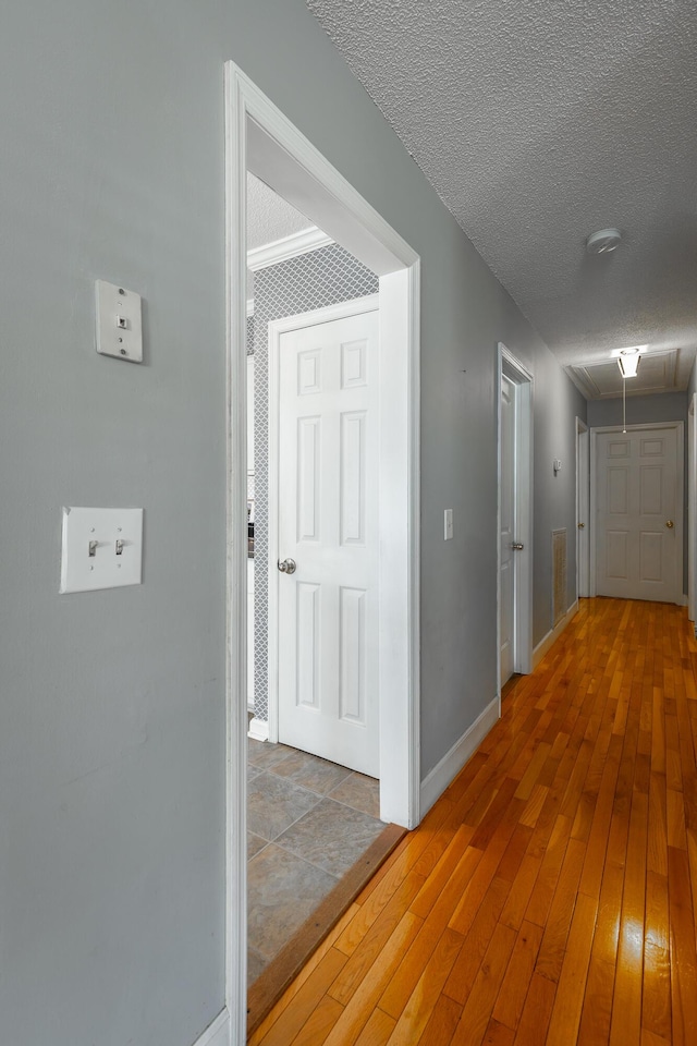 hall featuring a textured ceiling and hardwood / wood-style flooring