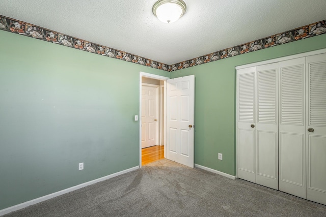 unfurnished bedroom with light carpet, a textured ceiling, and a closet