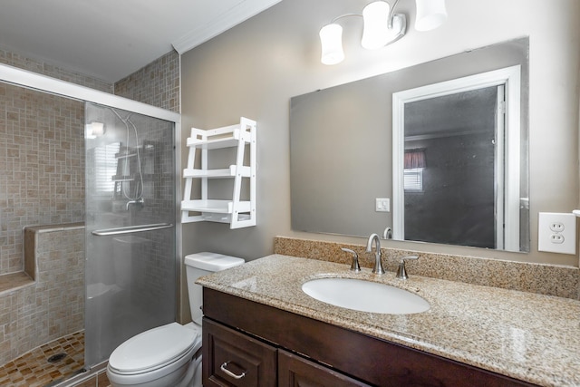 bathroom featuring vanity, toilet, and a shower with shower door