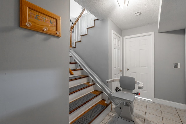 stairs with a textured ceiling and tile patterned floors