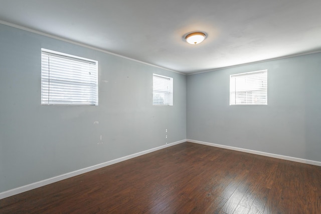 unfurnished room featuring dark hardwood / wood-style flooring and ornamental molding