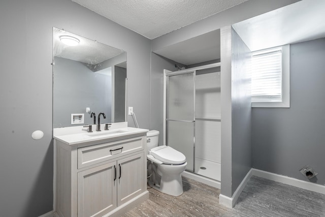 bathroom with an enclosed shower, toilet, a textured ceiling, vanity, and hardwood / wood-style flooring