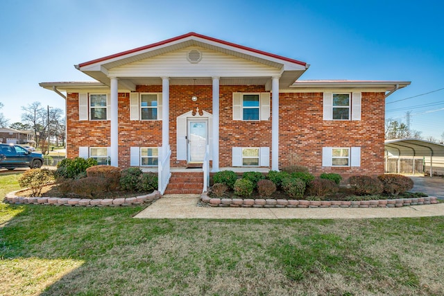 raised ranch with a front lawn and a carport