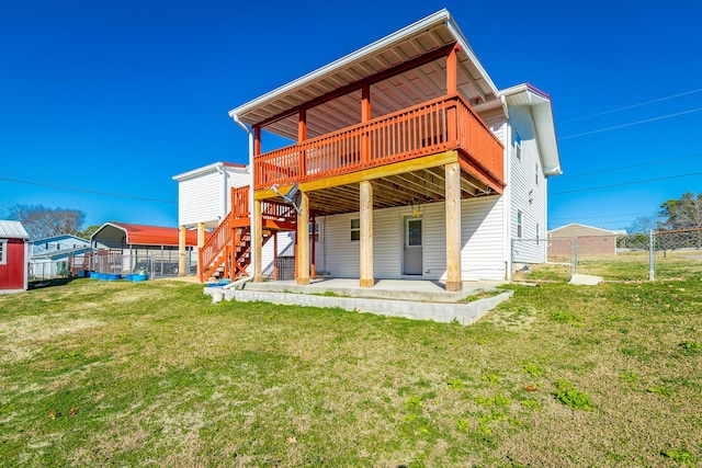 back of house with a wooden deck, a yard, and a patio