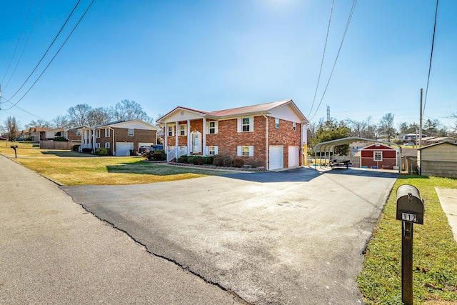 view of front of house with a carport, a garage, a storage shed, and a front yard