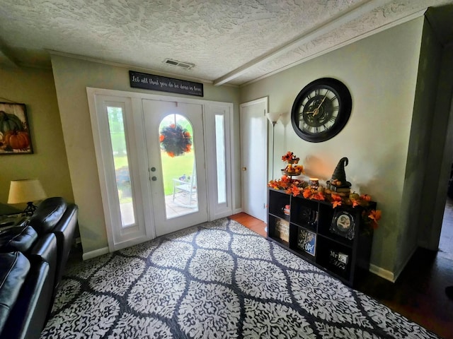 foyer entrance featuring crown molding and a textured ceiling