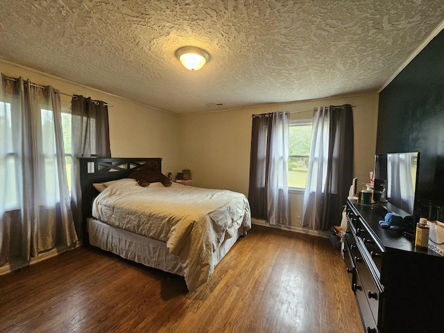 bedroom featuring hardwood / wood-style floors, crown molding, and a textured ceiling