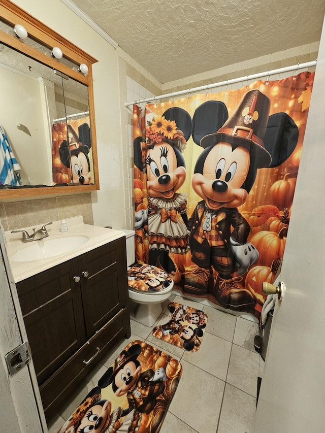 bathroom with vanity, crown molding, tile patterned flooring, toilet, and a textured ceiling