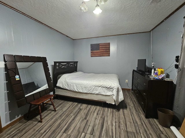 bedroom with crown molding, wood-type flooring, and a textured ceiling