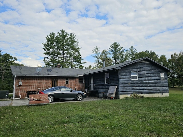 view of property exterior with a lawn and central AC unit