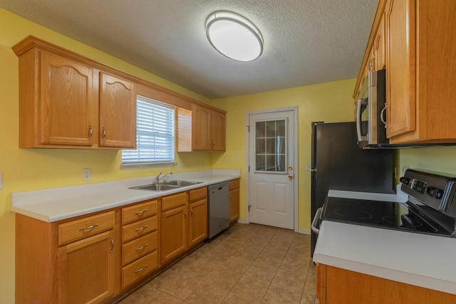 kitchen featuring appliances with stainless steel finishes, a textured ceiling, sink, and light tile patterned floors