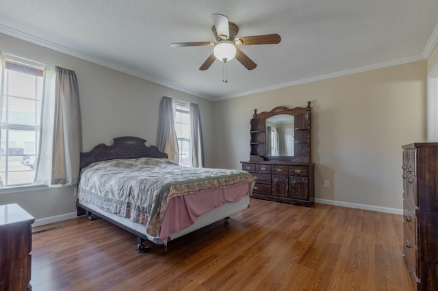 bedroom featuring ceiling fan, crown molding, a textured ceiling, and hardwood / wood-style flooring